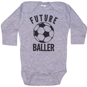 May include: Gray long-sleeve baby onesie with a black soccer ball and the text "FUTURE BALLER".
