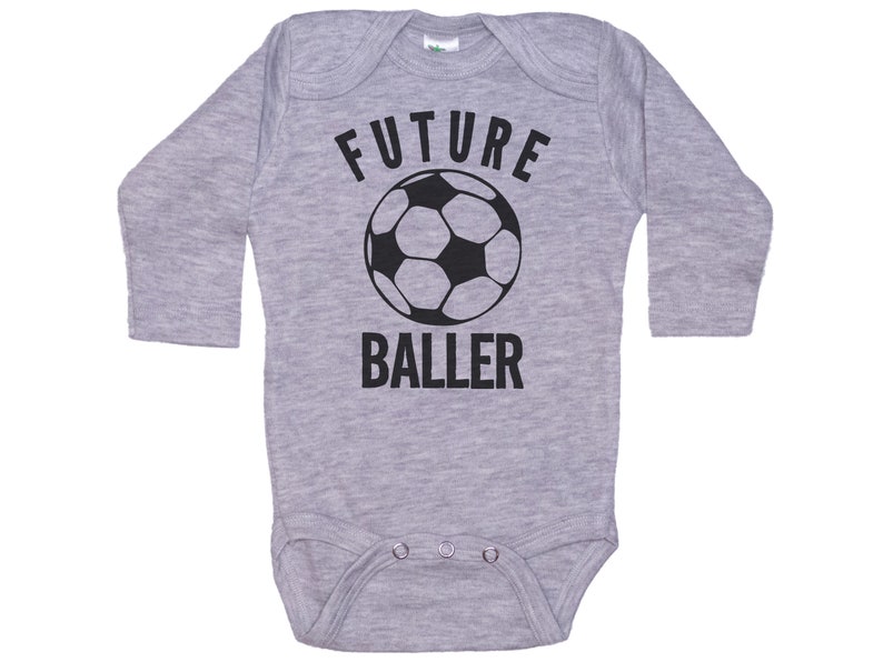 May include: Gray long-sleeve baby onesie with a black soccer ball and the text "FUTURE BALLER".