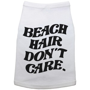 May include: White dog shirt with black text that reads "Beach Hair Don't Care."