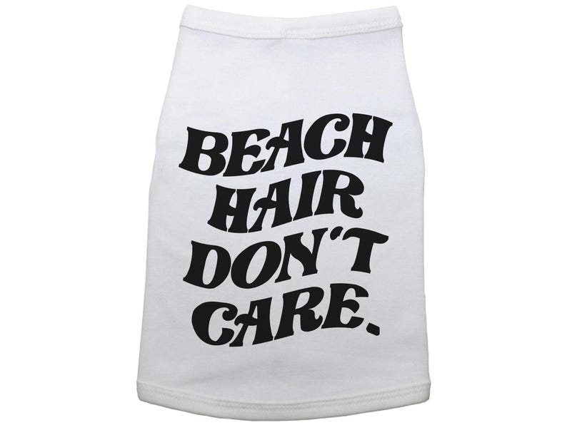 May include: White dog shirt with black text that reads "Beach Hair Don't Care."