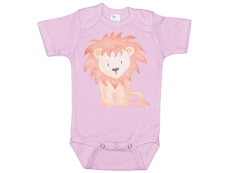 May include: A pink baby onesie with a watercolor illustration of a lion. The lion is orange and brown with a red mane.