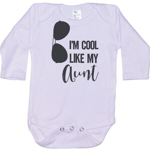 May include: White long-sleeve baby onesie with black text that reads "I'm cool like my aunt" and a pair of sunglasses graphic.