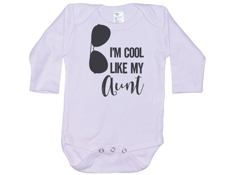 May include: White long-sleeve baby onesie with black text that reads "I'm cool like my aunt" and a pair of sunglasses graphic.