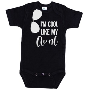May include: Black baby onesie with white text that reads "I'm cool like my aunt" and a pair of sunglasses graphic.
