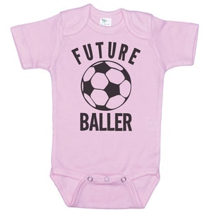 May include: Pink baby onesie with a black soccer ball and the text "FUTURE BALLER".