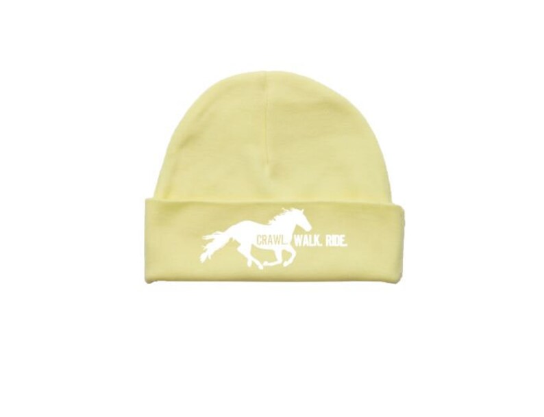 May include: A yellow beanie with a white silhouette of a horse running and the text "Crawl. Walk. Ride."
