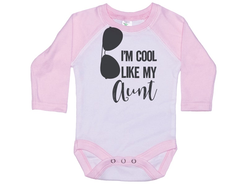 May include: Pink and white long-sleeved baby onesie with a black graphic of sunglasses and the text "I'm cool like my aunt".