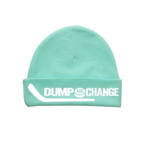 May include: A turquoise blue beanie with a white hockey stick and puck graphic and the text "DUMP AND CHANGE".
