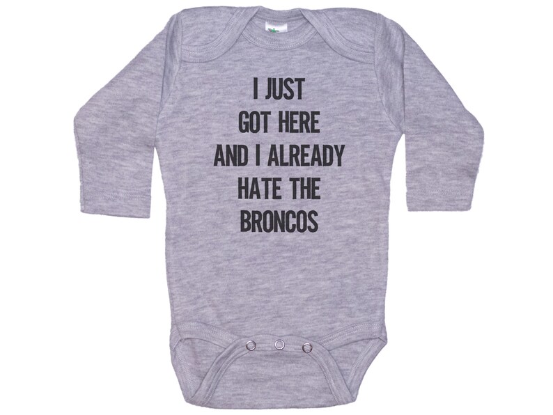 May include: Gray long-sleeve baby onesie with the text "I just got here and I already hate the Broncos".
