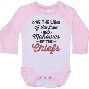 Pode incluir: Macac&atilde;o de beb&ecirc; de manga comprida rosa e branco com um gr&aacute;fico branco e vermelho que diz "O're the land of the free and Mahomes -of the- Chiefs".