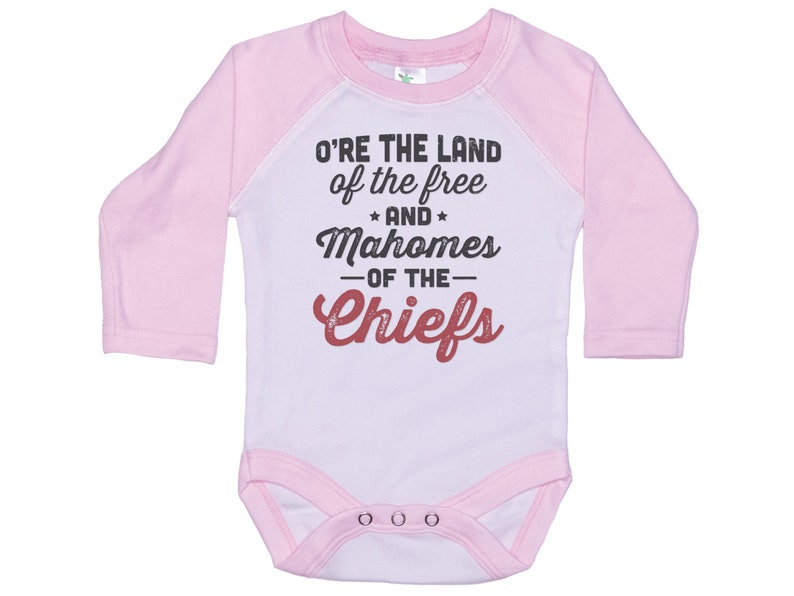 Pode incluir: Macac&atilde;o de beb&ecirc; de manga comprida rosa e branco com um gr&aacute;fico branco e vermelho que diz "O're the land of the free and Mahomes -of the- Chiefs".