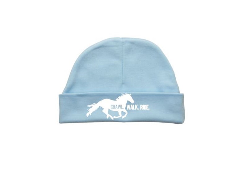 May include: A light blue baby beanie with a white silhouette of a horse running and the text "Crawl. Walk. Ride."