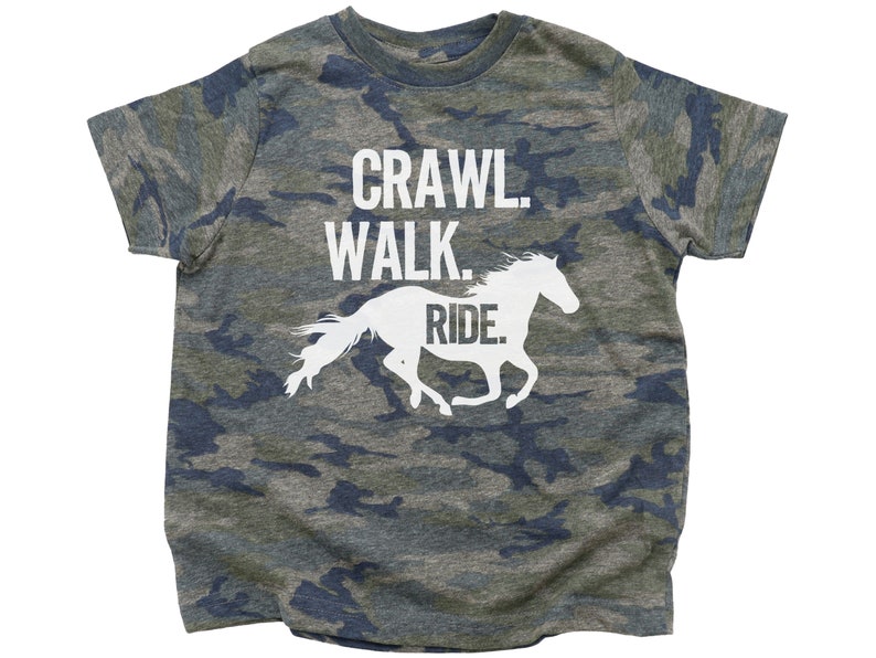 May include: A camouflage-patterned t-shirt with the text "Crawl. Walk. Ride." and a white silhouette of a horse running.