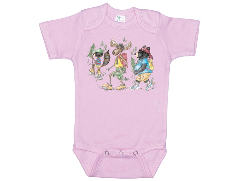 May include: Pink baby onesie with a graphic of a raccoon, moose, and bear wearing backpacks and hiking in the woods.