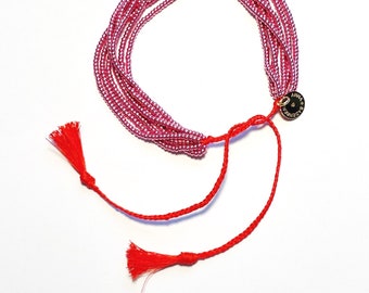 BRACELET made of tiny glass beads (rocailles) in violet metallic, in seven rows and handmade tassels