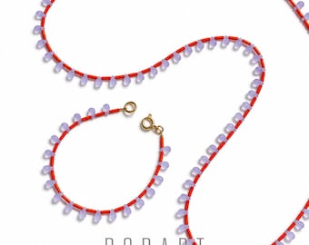 Collana composta da gocce di vetro color viola ghiaccio, con bacchette di vetro arancione interposte, collana lunga o bracciale nello stesso stile, design minimalista