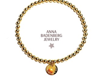 Bracelet made of sterling silver beads (4 mm), 24kt gold plated and a logo pendant. Stretch bracelet