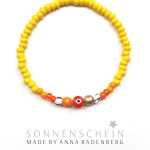 BRACELET made of glass beads (rocailles) in yellow opaque, millefiori, spacer evil eye made of glass, set sterling silver 24Kt gold plated
