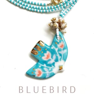 Necklace: Ceramic pendant with dove motif and Java pearl tassel on a Preciosa glass bead necklace in blue and white, cultured pearl, maritime style.