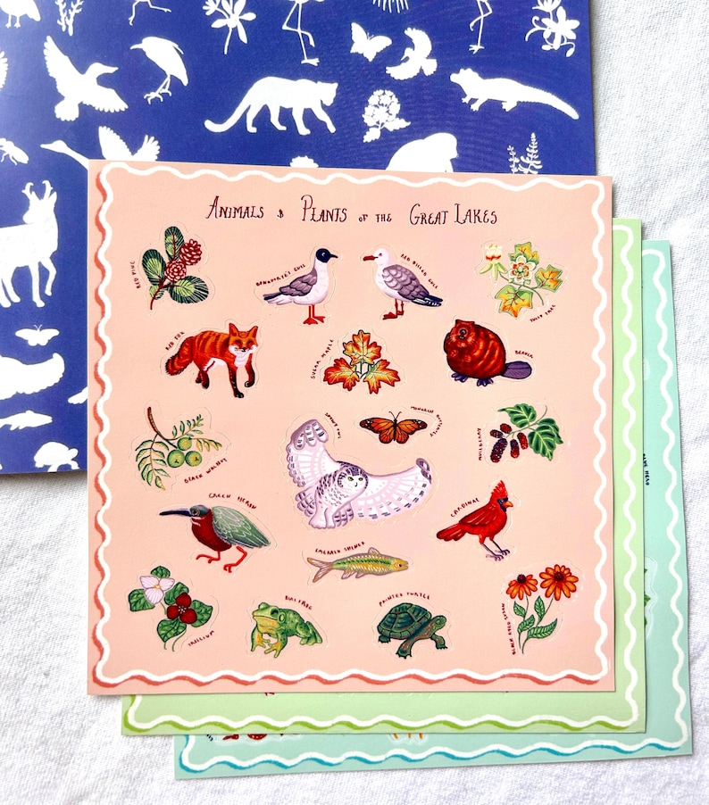 May include: A set of stickers illustrating animals and plants of the Great Lakes. The stickers feature a fox, owl, cardinal, and other wildlife, with the text "Animals & Plants of the Great Lakes" at the top. The stickers are on a pink background with a scalloped border.