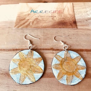 Pendientes artesanales realizados con cartón reciclado.