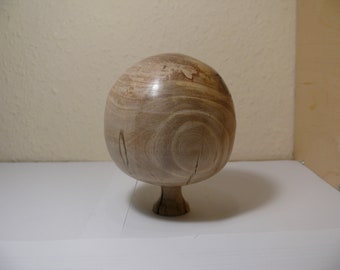 Wooden ball standing made of walnut tree.