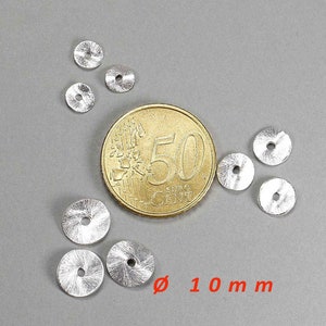 May include: A collection of small, silver-colored, disc-shaped beads with a central hole, scattered on a gray surface. A gold coin is next to the beads for size comparison. The text "&oslash; 10 mm" is in red.