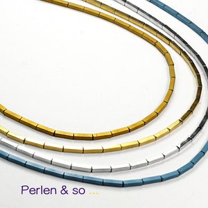Könnte beinhalten: Vier Halsketten mit geometrischen, rechteckigen Perlen in Gold, Silber, Schwarz und Blau. Die Halsketten werden auf weißem Hintergrund präsentiert. Der Text "Perlen & so ..." ist unten sichtbar.