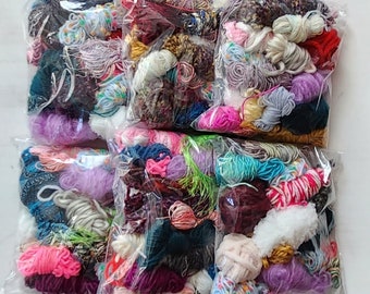 May include: Assortment of colorful yarn scraps in clear plastic bags. The yarn is in various colors, textures, and lengths.