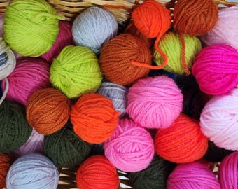 May include: A basket filled with colorful yarn balls in various shades of pink, green, blue, orange, and brown. The yarn is soft and fluffy, perfect for knitting or crocheting.