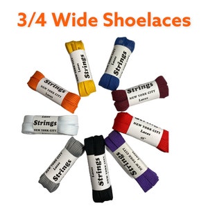 Peut inclure: Assortiment de lacets de 3/4 de pouce de large dans diff&eacute;rentes couleurs, notamment blanc, noir, gris, orange, rouge, violet, bleu et jaune. Chaque lacet est &eacute;tiquet&eacute; "Strings" avec le texte "New York City" et "Laces".