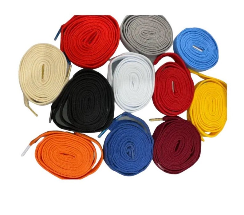 Peut inclure: Assortiment de 12 lacets de chaussures de diff&eacute;rentes couleurs, dont le rouge, le blanc, le bleu, le noir, le jaune, l'orange et le marron. Les lacets sont enroul&eacute;s et dispos&eacute;s en cercle.