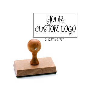 May include: A wooden stamp with a handle and the text "YOUR CUSTOM LOGO". The stamp measures 2.125" x 3.75". The stamp has a wooden base and a wooden handle with a rounded top.