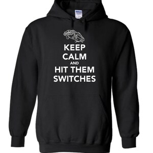 May include: Black hooded sweatshirt with a white graphic of a car flying in the air and the text "Keep Calm and Hit Them Switches".