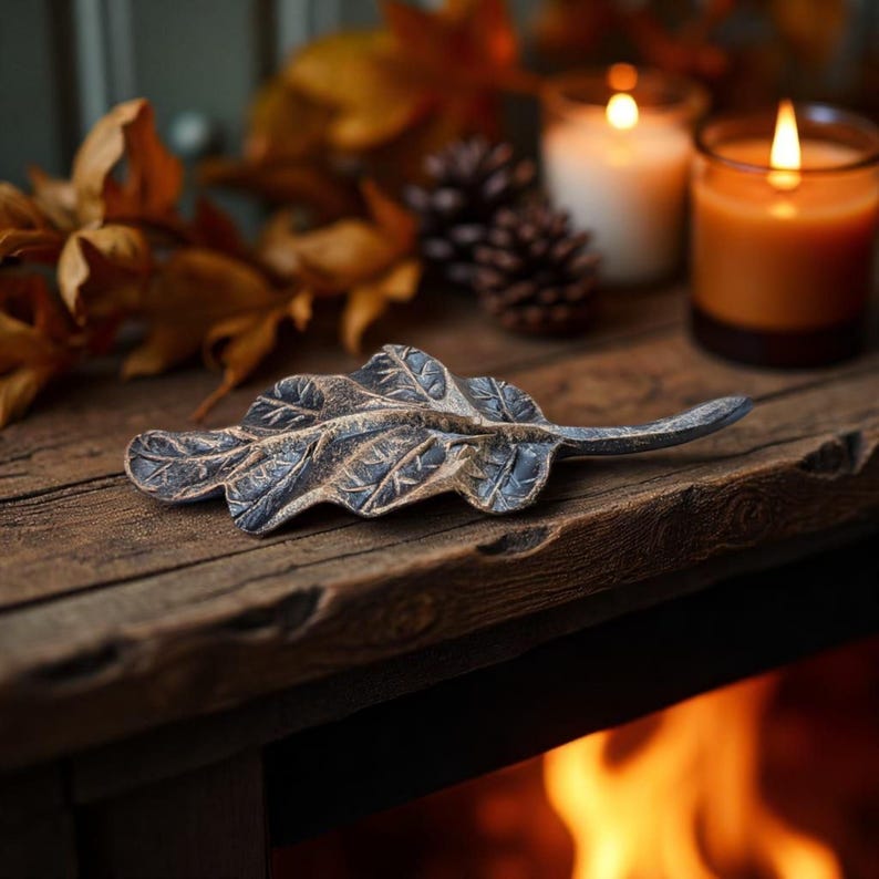 Thanksgiving table setting with candles, pinecones, and forged leaves.