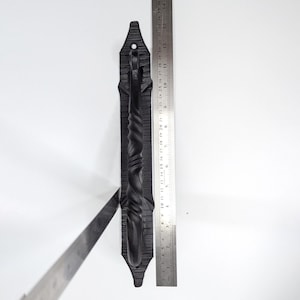 K&ouml;nnte beinhalten: Schwarzer Schmiedeeisener T&uuml;rgriff mit einem gedrehten Design. Der Griff ist etwa 25 cm lang und auf einer flachen Platte montiert.