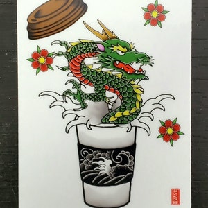 May include: A green and red dragon with yellow horns emerges from a white coffee cup with a black and white wave design. The dragon is surrounded by four red flowers with yellow centers. A brown lid is flying above the dragon.