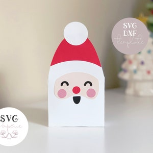 Może przedstawiać: Drukowany szablon pudełka Świętego Mikołaja do rękodzieła. Szablon to czerwony i biały Święty Mikołaj z białą brodą i czerwonym kapeluszem. Szablon jest oznaczony jako "Szablon SVG DXF".