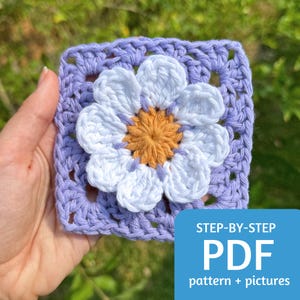 Peut inclure: Un carré au crochet avec une fleur blanche au centre. La fleur a un centre jaune et six pétales. Le carré est de couleur violet clair. Le texte "STEP-BY-STEP PDF pattern + pictures" est en bas de l'image.