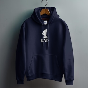 May include: Navy blue hoodie featuring a white chess piece graphic and the word "GAD". The hooded sweatshirt has a front pocket and drawstring. It is displayed on a wooden hanger.