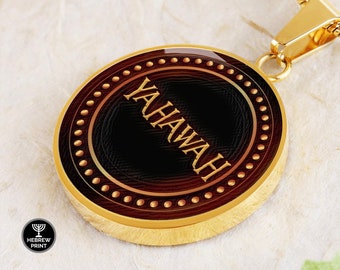 May include: Gold-tone pendant necklace with the word "YAHAWAH" in gold lettering. The oval pendant has a dark brown center, a gold border with small gold dots, and a gold-colored chain. The Hebrew Print logo is visible in the lower left corner.