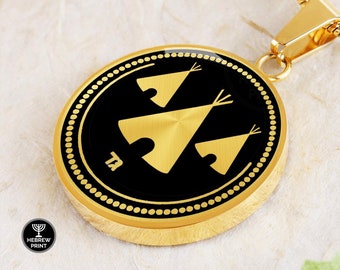 May include: Gold pendant necklace with a black circular charm featuring three gold teepees and the Hebrew letter 'Tet' in the center. The pendant is surrounded by a gold beaded border.