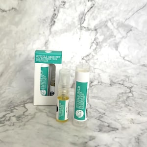 May include: A cuticle care set in a white box with green text. The set includes a cuticle balm and a cuticle oil. The balm is in a white tube with green text and the oil is in a clear bottle with a gold cap.