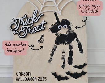 May include: A wooden Halloween decoration with a handprint design, googly eyes, and the words "Trick or Treat." The decoration includes a spiderweb, bats, and the text "CARSON HALLOWEEN 2025." It is designed to be personalized.