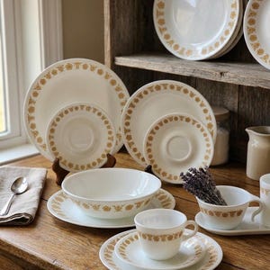 May include: A set of three ceramic mugs with a speckled, matte finish. The mugs are in shades of cream, light gray, and dark gray. Each mug has a simple, minimalist design and a rounded handle. The mugs are stacked on top of each other.