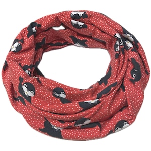 Könnte beinhalten: Roter Loop-Schal mit einem Muster aus Cartoon-Pinguinen und weißen Tupfen. Die Pinguine sind schwarz und weiß. Der Schal besteht aus einem weichen, leichten Stoff, ideal für kühleres Wetter.