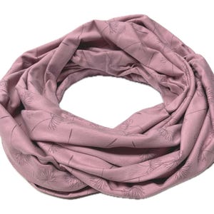 Könnte beinhalten: Ein rosafarbener Infinity-Schal mit einem zarten Blumenmuster. Der Schal ist aus einem weichen, dehnbaren Stoff gefertigt und perfekt, um jedem Outfit einen Hauch von Stil zu verleihen.