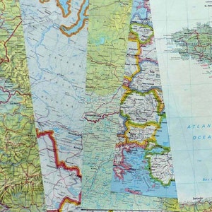 Op de afbeelding: Een verzameling kleurrijke, vintage kaarten, elk met verschillende geografische regio's. De kaarten bevatten gedetailleerde illustraties van landvormen, wegen en wateren, met een verscheidenheid aan kleuren en tekstlabels. De kaarten zijn verticaal en overlappend gerangschikt.