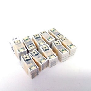 May include: Ten stacks of miniature fake US dollar bills, each stack is about 1.7 inches tall and 0.7 inches wide.