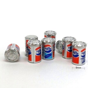 May include: Six miniature silver cans of soda pop, each with a red, white, and blue label that reads "Soda Pop". The cans are 1.25 inches tall and 0.9 inches wide.